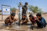 Children drinking clean water from a community water well installed through the End Water Crisis initiative in Pakistan.